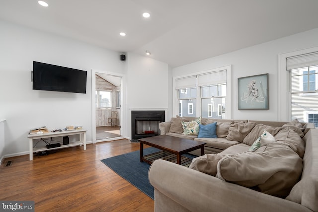 living room with plenty of natural light, dark hardwood / wood-style flooring, and lofted ceiling