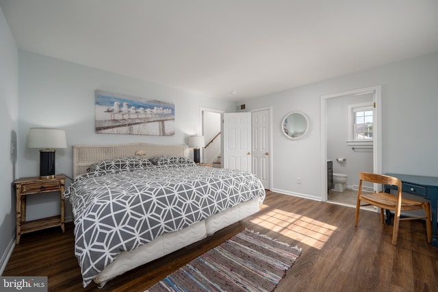 bedroom with ensuite bath and dark wood-type flooring