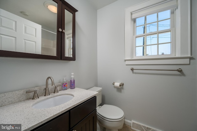 bathroom with a shower, vanity, and toilet