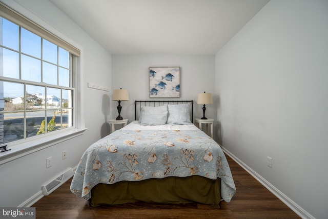 bedroom with dark wood-type flooring and multiple windows