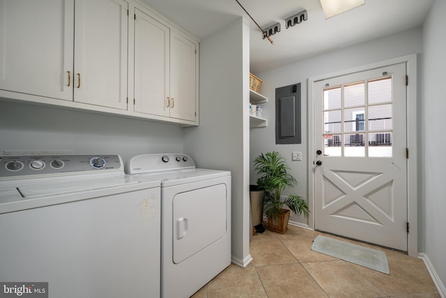 washroom with cabinets, electric panel, light tile patterned flooring, and washing machine and clothes dryer