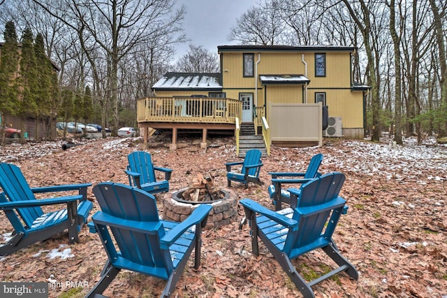 rear view of house featuring a deck and an outdoor fire pit