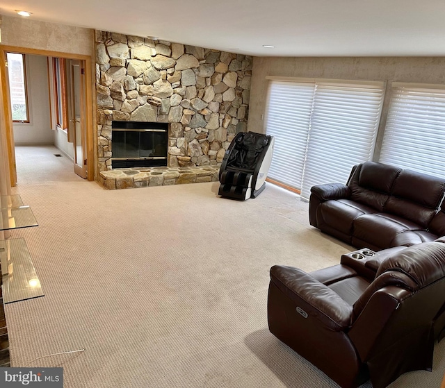 living room with light carpet and a stone fireplace