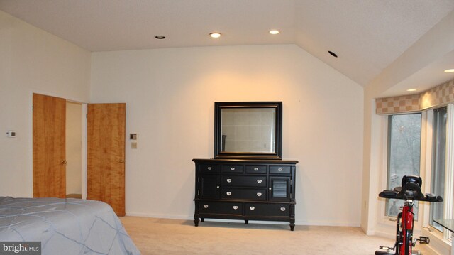 bedroom featuring lofted ceiling and light colored carpet