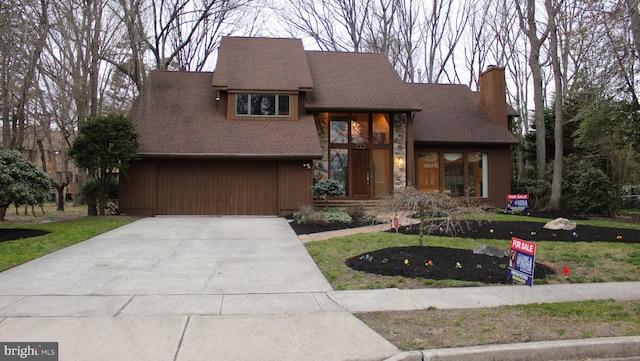 view of front of house featuring a garage and a front lawn