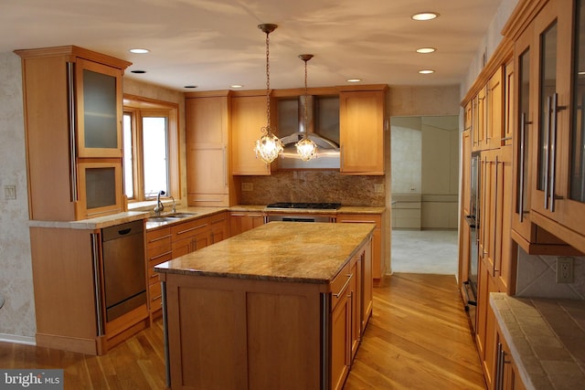 kitchen with pendant lighting, wall chimney exhaust hood, a kitchen island, and light hardwood / wood-style flooring