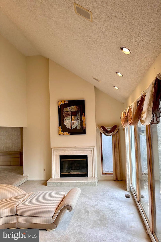 unfurnished living room featuring a premium fireplace, lofted ceiling, light colored carpet, and a textured ceiling