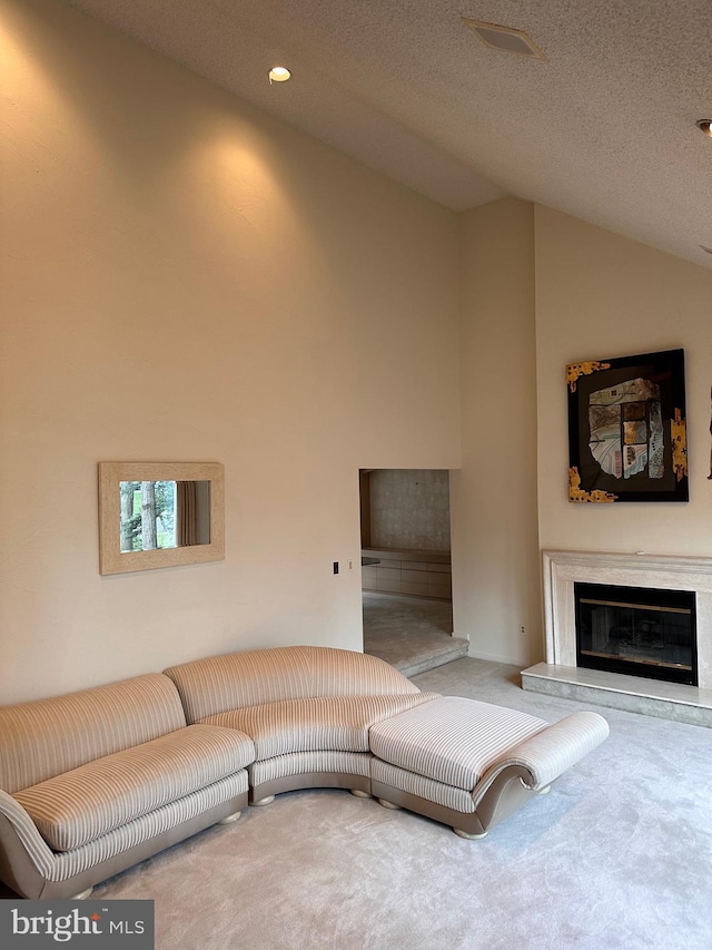 living room featuring high vaulted ceiling, a premium fireplace, carpet floors, and a textured ceiling