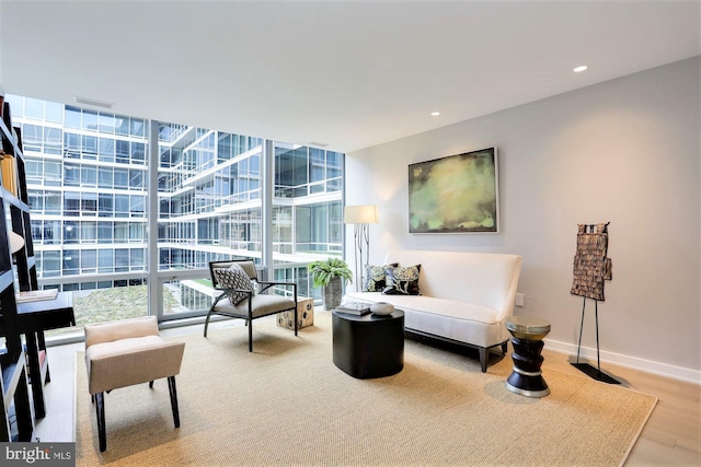 sitting room featuring wood-type flooring and floor to ceiling windows