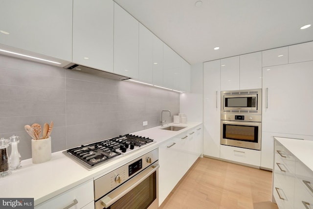 kitchen featuring white cabinets, sink, appliances with stainless steel finishes, and tasteful backsplash