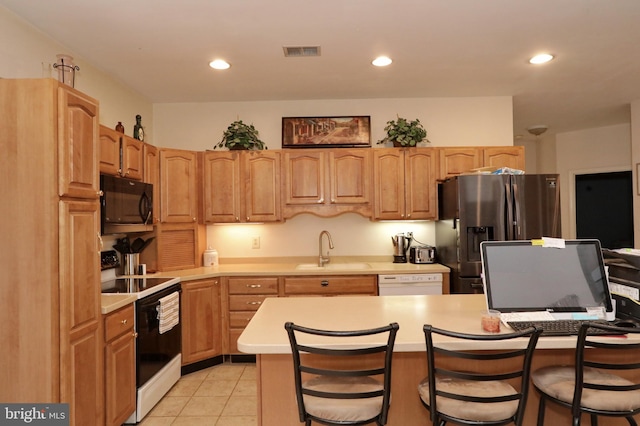 kitchen with sink, a kitchen breakfast bar, light tile patterned flooring, white appliances, and a kitchen island