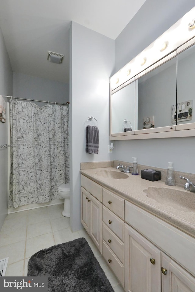 bathroom featuring tile patterned flooring, vanity, and toilet