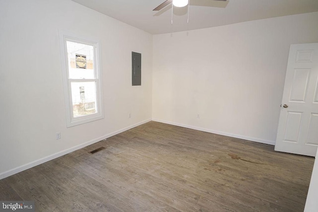 unfurnished room featuring dark hardwood / wood-style floors, ceiling fan, and electric panel