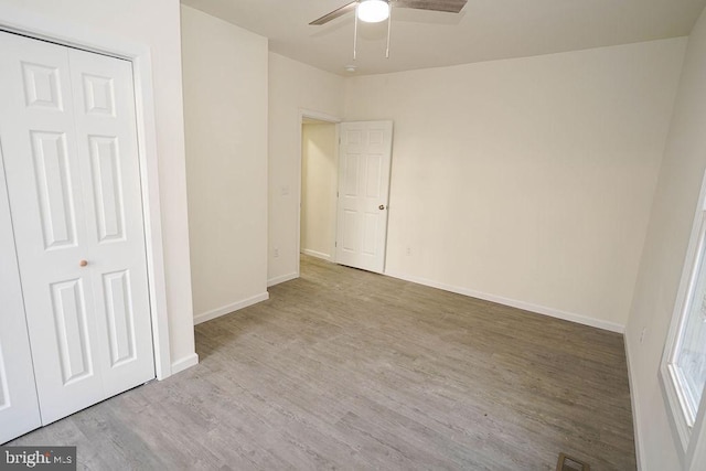 unfurnished bedroom featuring ceiling fan, light wood-type flooring, and a closet