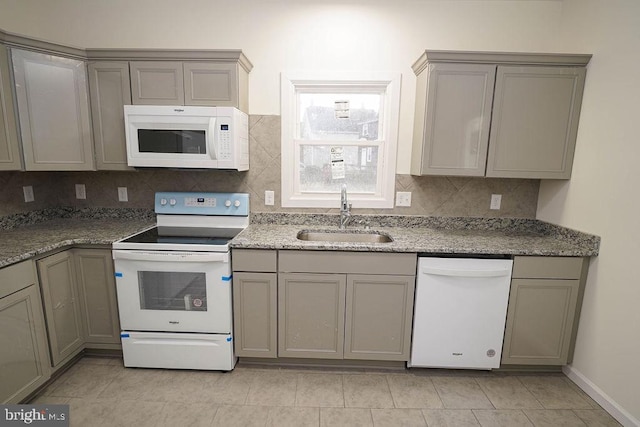 kitchen with light tile patterned flooring, white appliances, gray cabinetry, and sink