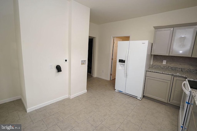 kitchen with light stone countertops, white appliances, tasteful backsplash, and gray cabinetry