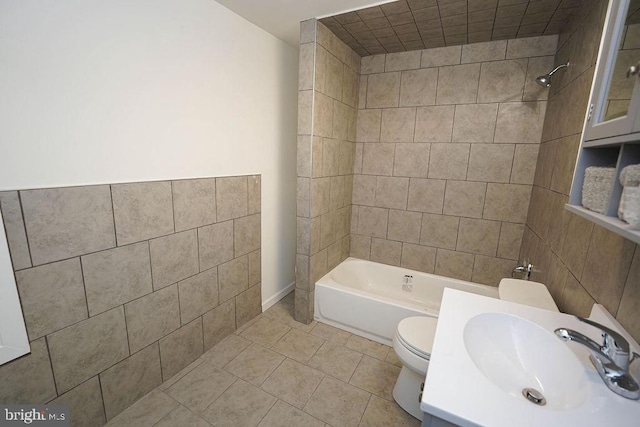 full bathroom featuring tile patterned floors, tiled shower / bath combo, toilet, and sink