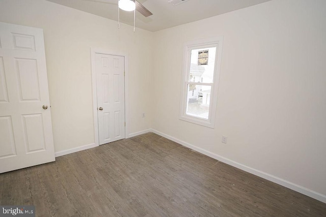 unfurnished room with dark hardwood / wood-style flooring and ceiling fan