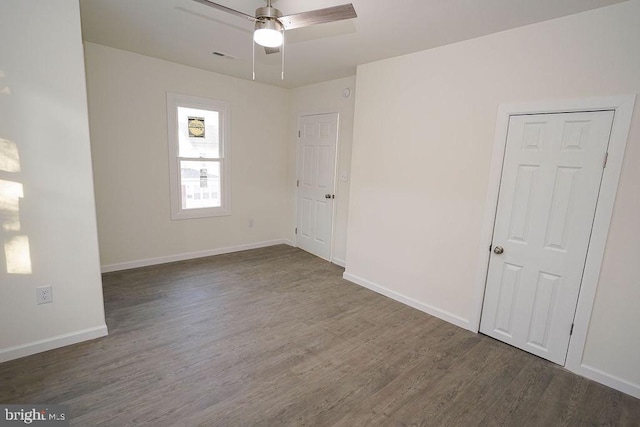 unfurnished room with dark hardwood / wood-style floors and ceiling fan