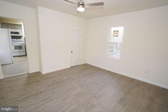 spare room with ceiling fan and hardwood / wood-style flooring