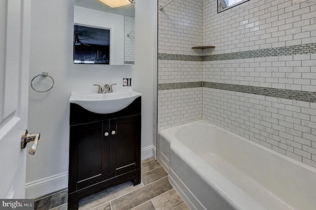 bathroom featuring hardwood / wood-style floors, tiled shower / bath combo, and vanity