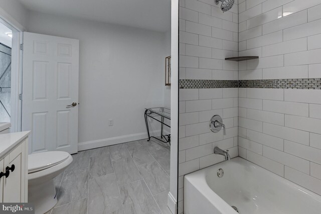 full bathroom featuring tile patterned floors, toilet, vanity, and tiled shower / bath