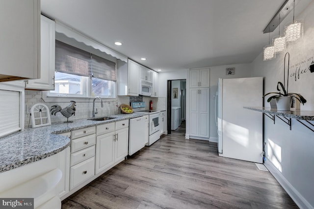 kitchen with light wood-type flooring, white appliances, and white cabinets