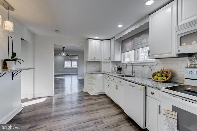 kitchen with sink, white cabinetry, light wood-type flooring, and white appliances