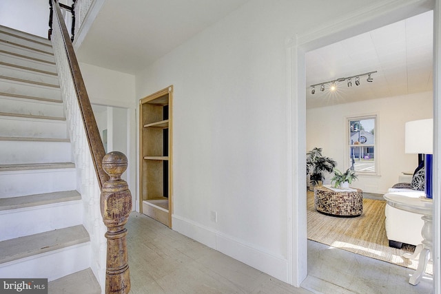 stairs featuring built in shelves and rail lighting