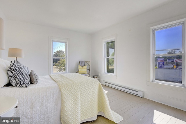 bedroom featuring a baseboard radiator and light hardwood / wood-style floors