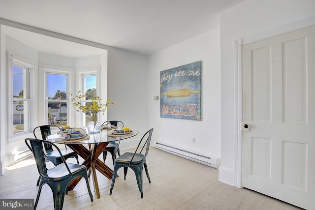 dining space featuring light wood-type flooring and a baseboard heating unit