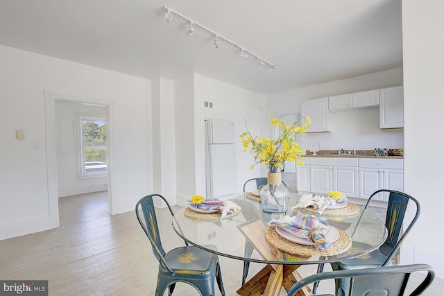 dining room featuring light wood-type flooring and sink