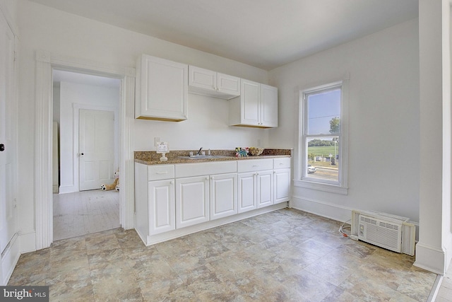 kitchen featuring white cabinetry, sink, and dark stone counters