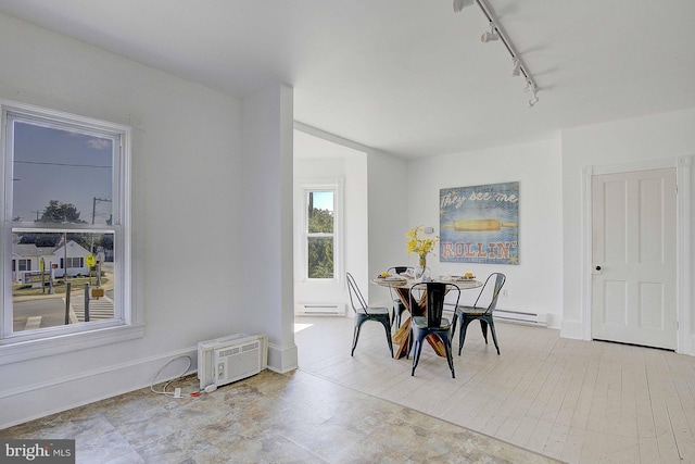 dining area featuring baseboard heating, a wall mounted air conditioner, and track lighting