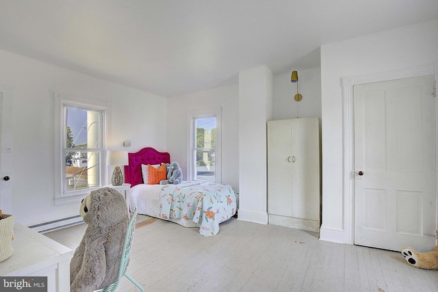 bedroom featuring hardwood / wood-style floors and baseboard heating