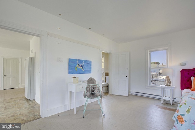 interior space with light wood-type flooring and a baseboard heating unit