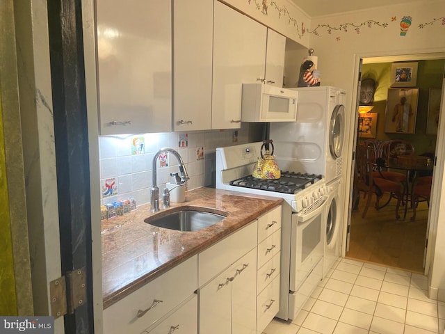 kitchen with white cabinetry, tasteful backsplash, white appliances, sink, and light tile patterned floors