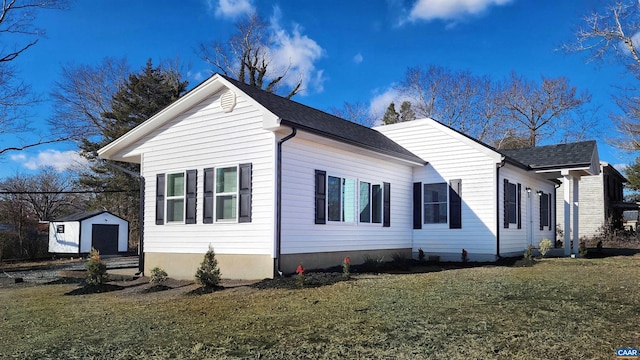 view of side of property with a yard and a storage shed