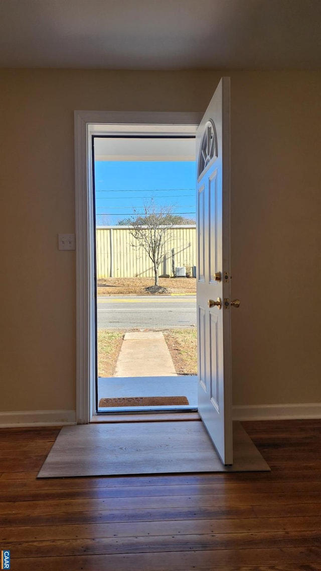 doorway with dark hardwood / wood-style floors and a healthy amount of sunlight