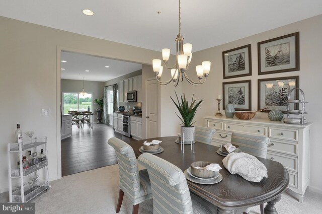 dining room featuring recessed lighting, light colored carpet, and an inviting chandelier