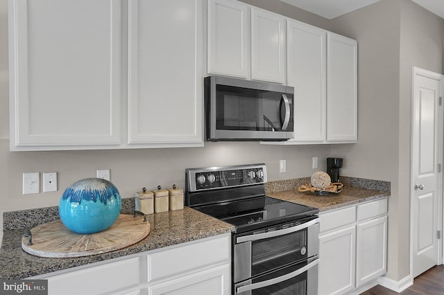kitchen with white cabinetry, stainless steel appliances, and light stone countertops