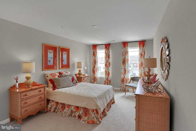 bedroom with light carpet and baseboards