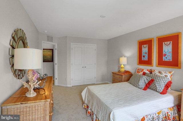 carpeted bedroom with a closet, baseboards, and visible vents