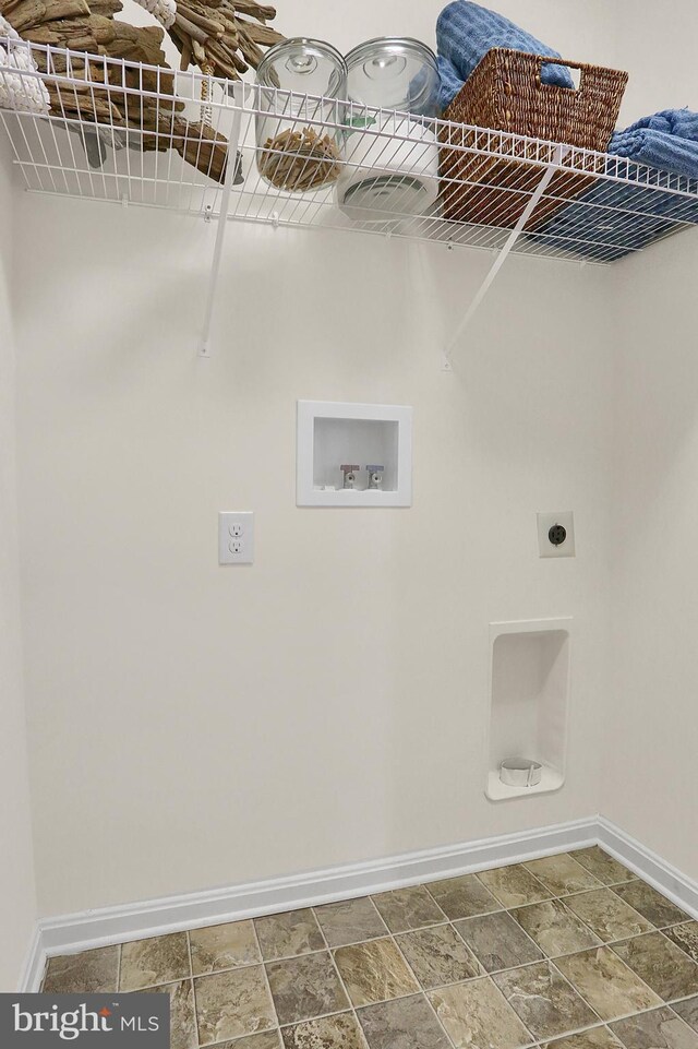 washroom with hookup for a washing machine, baseboards, hookup for an electric dryer, and stone finish flooring