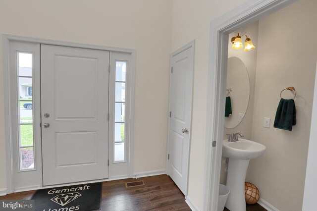 entryway featuring dark wood finished floors, visible vents, and baseboards