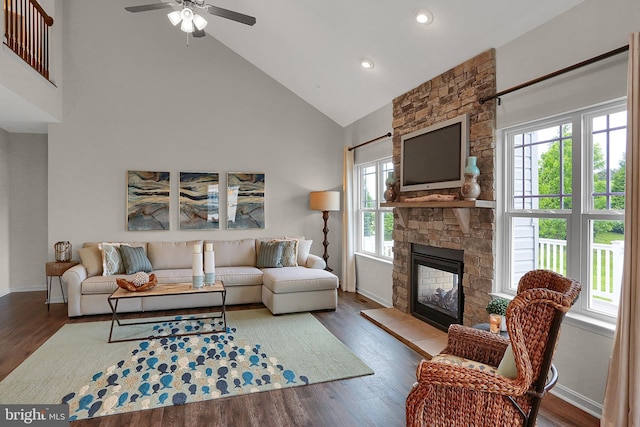living area featuring a stone fireplace, high vaulted ceiling, a ceiling fan, and wood finished floors