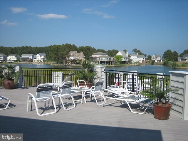wooden terrace with a residential view and a water view