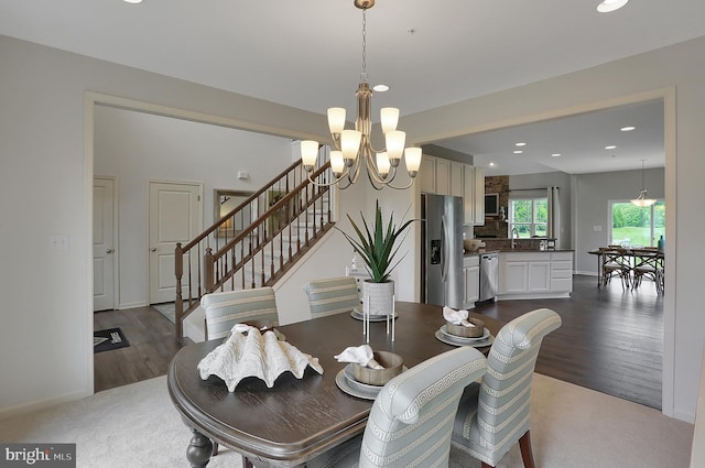 dining area with stairway, baseboards, an inviting chandelier, recessed lighting, and dark wood-type flooring