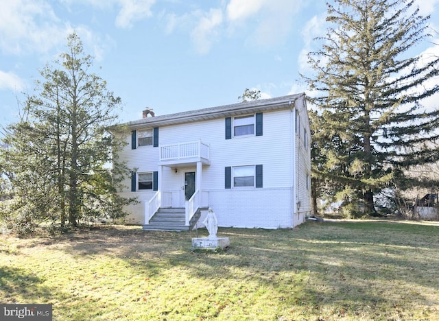 view of front of home with a front yard and a balcony