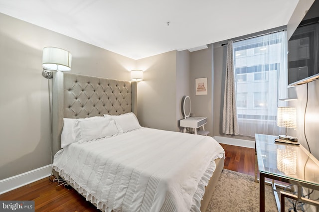 bedroom with dark hardwood / wood-style floors